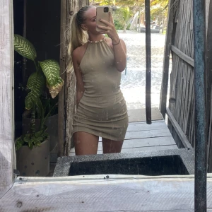 Beige klänning  - Beige / brun halvstickad klänning från hm, bra som tex strandklänning är använd 3 gånger i Mexico 