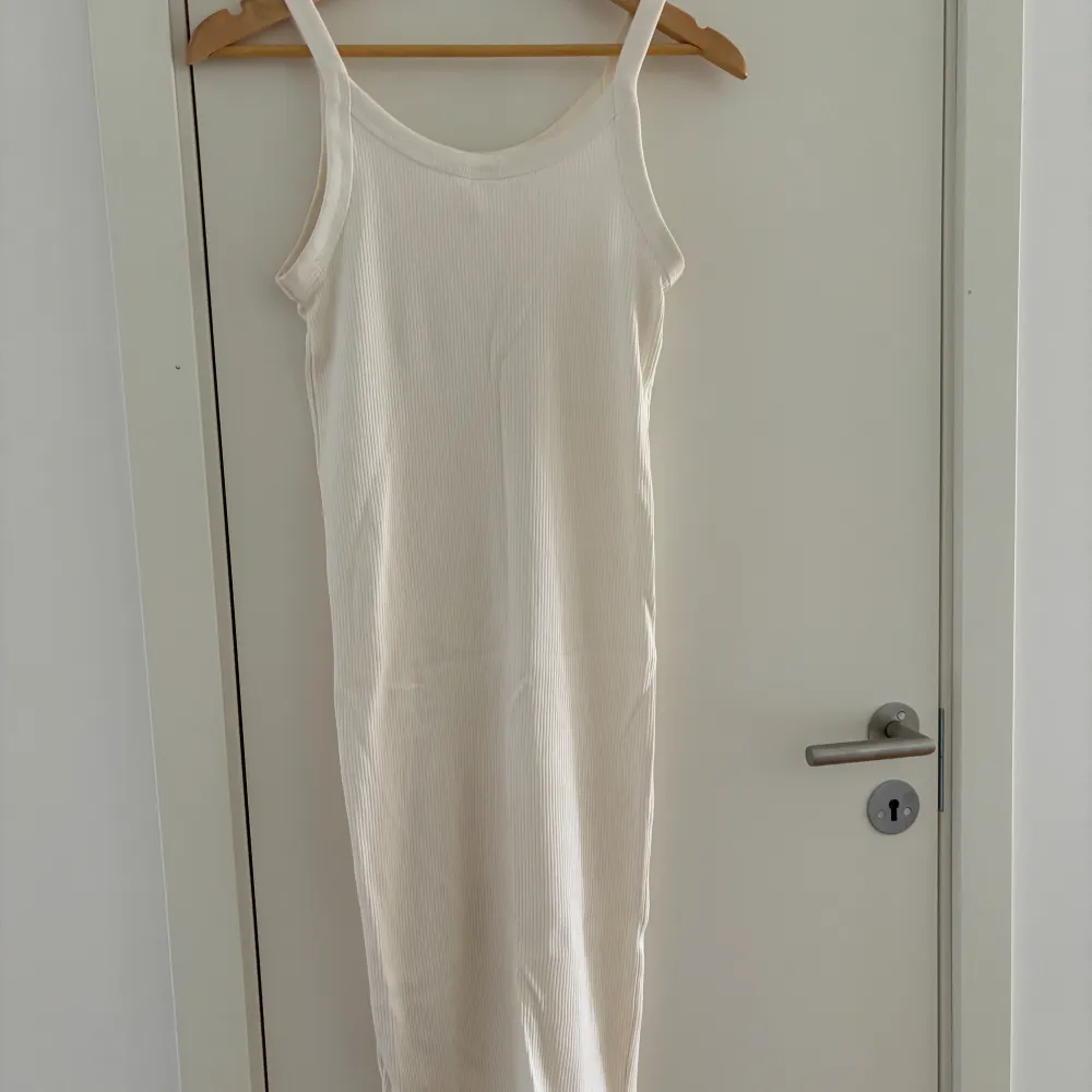 Säljer en vit knälång klänning från H&M i storlek XS, formar kroppen väldigt fint och är extremt stretchig, använd fåtal gånger och i mycket fint skick! Perfekt nu till sommaren!. Mekot.