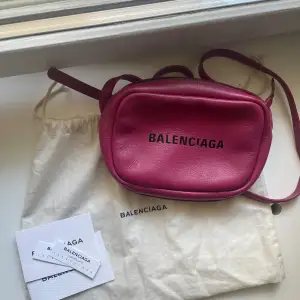 Säljer min coola Balenciaga väska i modellen camera bag i en rosa jätte fin färg! Väskan är flitigt använd därmed har den släppt lite i bandet (se bilder), men går att laga med textil limm. Till utseendet har den inga  defekter i färg osv.  