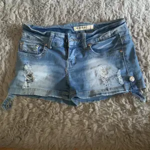Lågmidjade jeansshorts med knapp grej p framsida/sida ish 