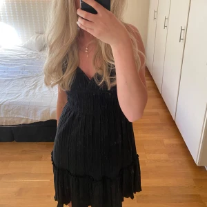 Svart kortklänning - Säljer denna assnygga kortklänning eftersom jag aldrig använder klänningar. Endast använd en gång förra sommaren och därför i nyskick💓 den har kors i ryggen vilket blir en skitsnygg detalj!