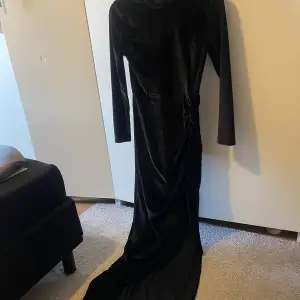 Lång svart klänning i sammet från nellys egna märke, har slits vid sidan och dragkedja bak. använd 1 gång