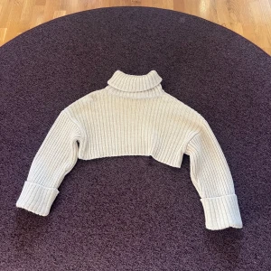 Stickad tröja  - En jättefin stickad croppad tröja från NA-KD!💗Har inte kunnat ha användning av den och därav aldrig använd🥰Den är lite kräm vit! Köpt för ca 500kr.