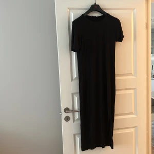 Svart NA-KD klänning - Svart klänning kortärmad med slits 