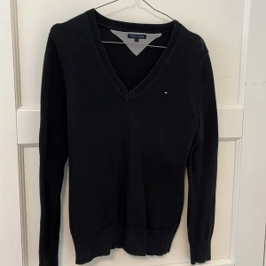 Tommy Hilfiger tröja - Svart stickad sweatshirt från Tommy Hilfiger. Något tjockare material. Storlek L (ungdom antar jag), passar S och M vuxen. 