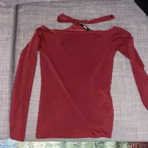 Säljer den här röda tröjan med choker då den inte används. Den knäpps med en knapp där bak i halsen