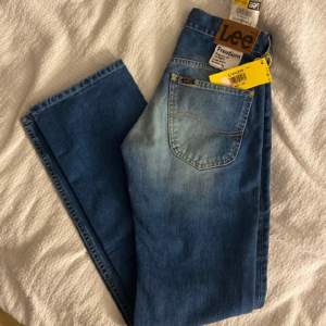 Helt oanvända lee jeans som är riktigt snygga!! W: 27 L:32 innerbenlängd: 80 cm Jeansen är mer flare och midd i midjan. 450 kr plus frakt!