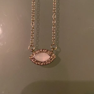 Halsband - Ett halsband som är köpt på Ur&penn. Märket är montini. Symbolen liknar ett öga. Har inte använts då den köptes i en surprisebag. Fint skick och ej rostig 🤍. Ordenarie pris 59kr. Köparen står för frakten och betalning sker via swisch 🥰