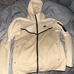 Beige Nike tech tröja - Jätte fin beige Nike tech tröja som är svår att få tag på nuförtiden, den är i storleken M men passar S. Jag säljer den för att jag har tröttnat på stilen