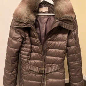 Michael Kors Jacka - Jackor & ytterplagg, stl. 36 (S), Dam Exklusiv oanvänd dunjacka från Michel Kors. Avtagbar luva, pälskrage, skärp. Anpassa jackan som du vill ha den. Nypris 4500 kr. 1200 kr
