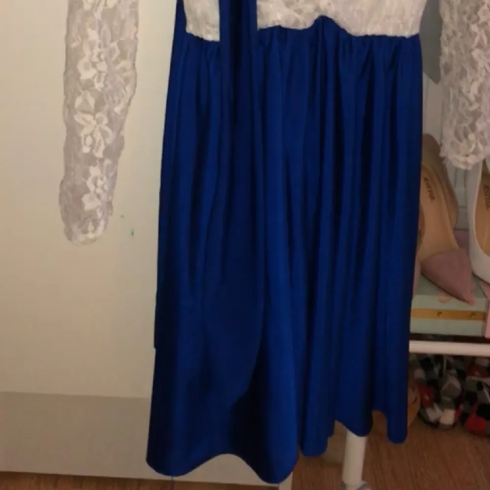 En vit och marinblå kort klänning med marinblått band . Klänningar.
