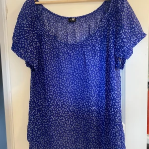 Blå blommig blus från JC - En super fin blå blus från JC i storlek L (nyskick).  Under kan man ha ett linne eller en bh och den går att styla på många olika sätt!!☺️🥳 Säljer eftersom den ej är i min storlek! 100% Polyester.