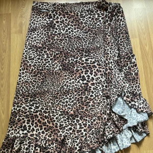 Kjol - Asymmetrisk leopardfärgad kjol i väldigt fint skick Använd 1-2 gånger bara Kommer inte ihåg vart jag köpt den men har för mig att den är ifrån BikBok eller GinaTricot I storlek S / M funkar vilket som då man knyter den runt själv.