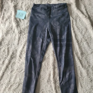 Mönstrade mörkblå strongertights  - Mörkblå mönstrade tights från Stronger. Lite natut/blad liknande mönstet och de klassiska två tjocka ränderna på ena benet. Användna ca 5 gånger. Nypris 899. Ficka baktill. Anons nr 13.