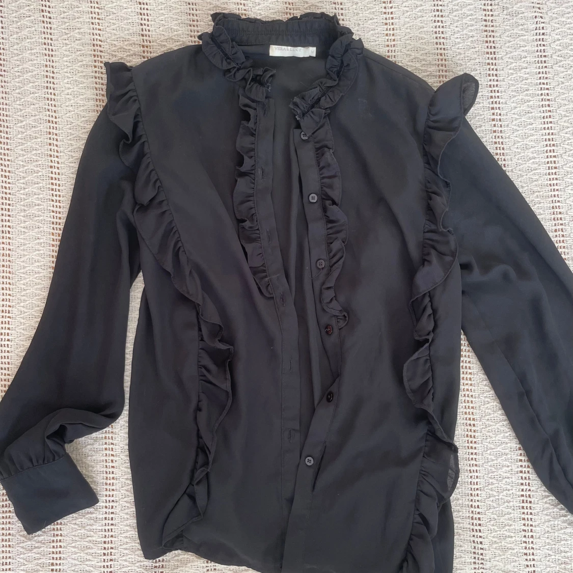 Svart blus med volanger