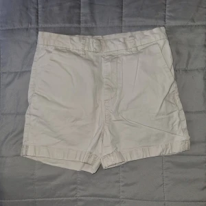 Vita shorts - Ett par beigea shorts med fickor fram och bak. De har en knappstängning och bälteshällor. Från H&M i stl 146, väldigt sparsamt använda.