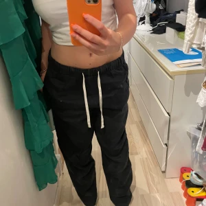 Mörkblå linnebyxor  - Mörkblå linnebyxor med vita snören. Lågmidja. 