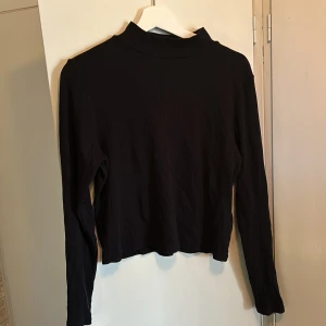 Topp - Ribbstickad tröja med kort polokrage på, mjuk och behaglig. Använt skick men inga större slitningar.