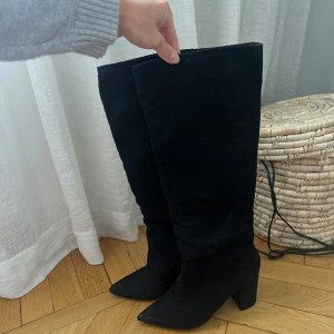 Högklackade stövlar  - Stövlar i mocka från Nelly, använda så det finns några märken på innersidan av ena skon men det syns inte då det är på insidan. Väldigt sköna! Säljer pga kommer ej till användning längre. Säljs på Nelly för 799kr. Klackhöjd 9cm, skafthöjd 40cm