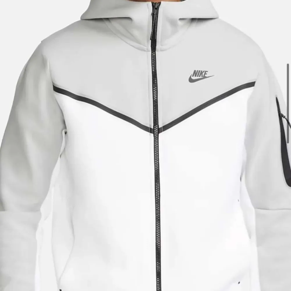 Säljer min grå vita Nike tech fleece, har inte använt den mycket men har ändå råkat få en liten fläck på ärmen. Skriv för fler bilder🥰. Hoodies.