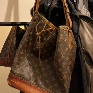 Loui Vuitton noe väska - Säljer min vintage loui vuitton väska💓 Den är i vintage skick och bandet till väskan är bytt🥰 Har ett äkthetsbevis från vintage bar💓