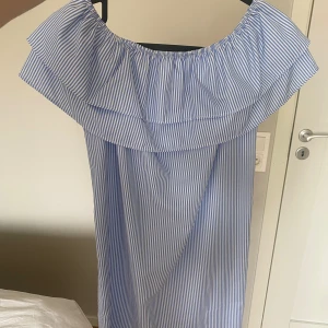 Somrig klänning från Dennis Maglic  - Blåvit-randig klänning från Dennis Maglic i storlek S, använd 2-3 gånger. Kommer med ett matchande band man kan knyta i midjan. Perfekt nu till sommaren 😍 säljer på grund av att den är för liten för mig