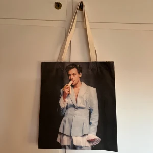 Harry Styles totebag/väska - Harry Styles totebag från butiken Ivan Alexis i Köpenhamn 🤍 Aldrig använd och i jättebra skicka då tyget är väldigt tåligt, rejält och tjockt 🤍