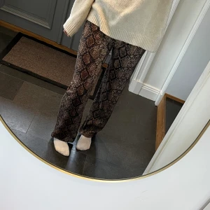 Lågmidjade mönstrade byxor - Ormskinnsönstrade lågmidjade byxor från Zara som jag har sytt om från ett par större högmidjade byxor. Fint skick. Passar mig som brukar ha S eller M och är 172. Använd gärna köp nu!