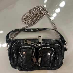 Nunoo väska - Väska ifrån nunoo, jättesöt och perfekt till fest! Väldigt rymlig med många fack. Använd men fortfarande i väldigt fint skick! 