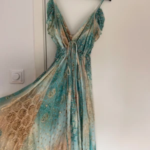 Mönstrad klänning - Säljer denna mönstrade långklänningen från en marknad i marbella. Endast använd 1 gång. Säljer då jag köpte flera styckna. Är 167cm och den släpar lite i marken! Passar xs-m då man kan spänna den i midjan🥰🥰