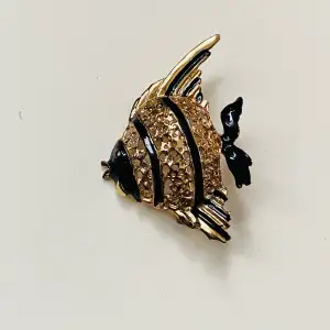 Fin brosch föreställande fisk i guld och svart 