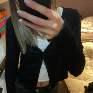 Svart topp - Svart topp/kofta från BikBok. Säljer pga den inte kommer till användning. Väldigt mjukt material & kolla sista bilden för att se ärmar samt botten av tröjan ! (Har knappar hela vägen ner)