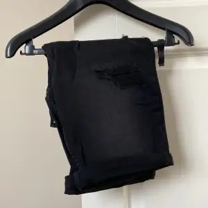 Ett par svarta snygga shorts med fake slitningar både i fram och bak. Dessa är helt oanvända och lappen sitter kvar.