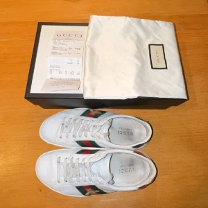 Gucci Ace Sneakers - Tjena, vi säljer nu dessa feta Gucci skor! Skick 8/10 inga större defekter som man märker, lite skador bak på skorna! Storleken på skorna är 42,5 fits 43! Allt OG medföljer. Ordinarie pris 7500kr vårt pris 2399!Hör av er vid intresse!