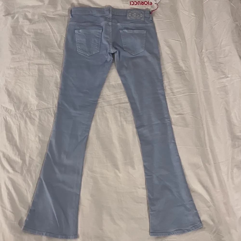 Fina ljusblåa lågmidjade jeans från fiorucci med prislapp kvar. Midja rakt över: 41,5 Innerbenslängd: 88cm, bredd längst ner: 23cm. Jättecoola jeans men säljer för att de inte passade mig! Kolla gärna in våra andra annonser!. Jeans & Byxor.