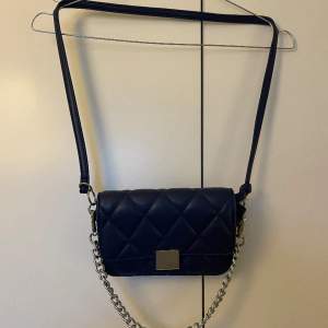 Mörkblå handväska i fejkläder, från glitter, med silver detaljer. 