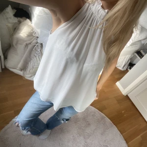 Vit topp/blus - En vit topp/blus med fint fall och hög hals.
