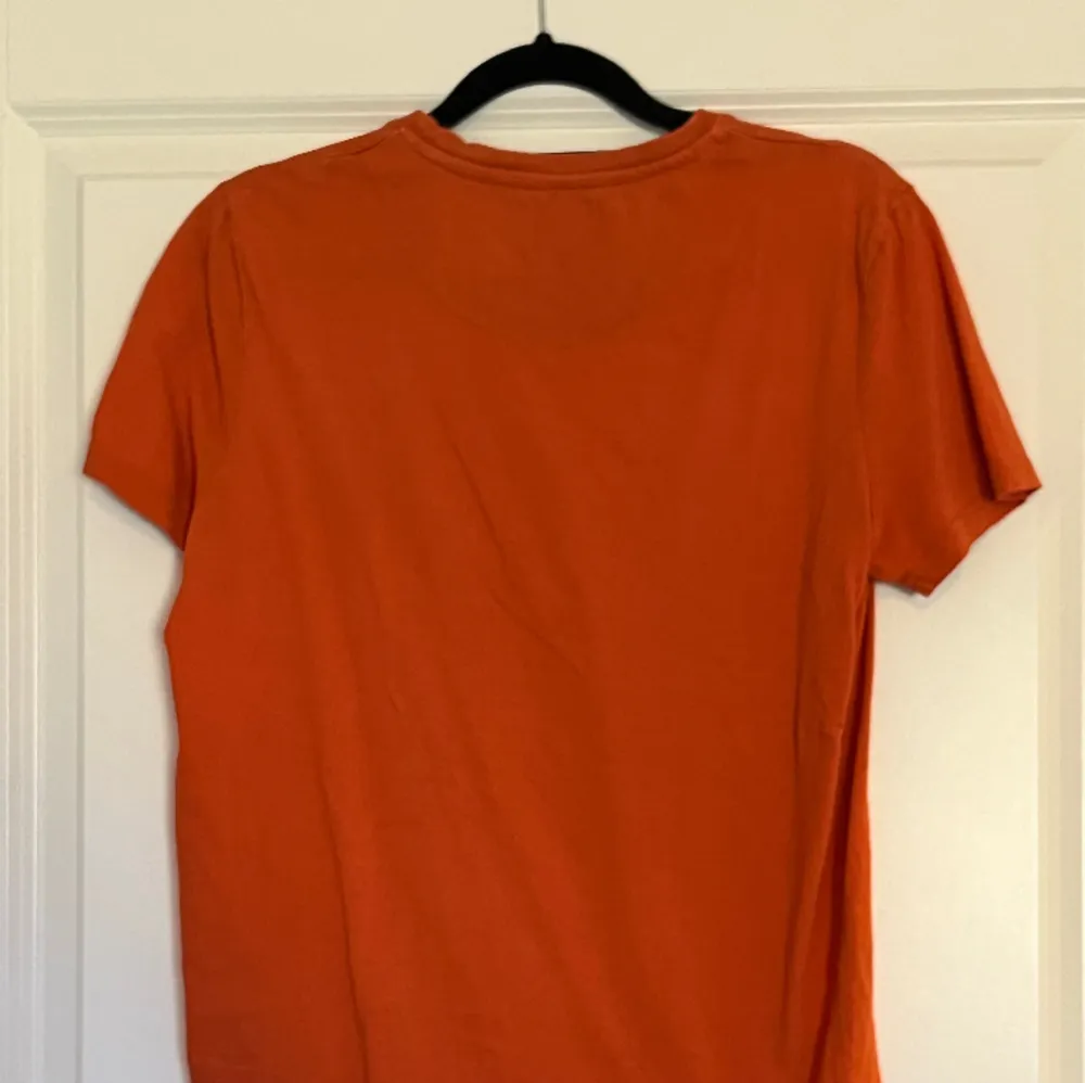 Väldigt stilig t-shirt. Bra skick i den. Den e lite mörk orange. . T-shirts.
