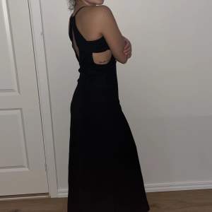 elegant svart klänning med cut-outs vid revbenen
