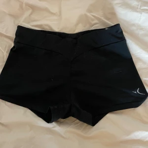 Träningsshorts - Fina träningsshorts med detalj där bak(se bild). Säljer för att jag har slutat på min sport och använder dem inte längre. De är i bra skick och fräscha!