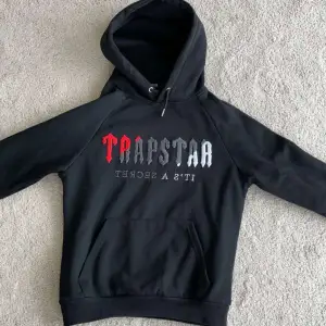 En svart Trapstar hoodie med röd puffig text nästan alldrig använd pris kan diskuteras och om du har några frågor är det bara att skriva och pris kan diskuteras 