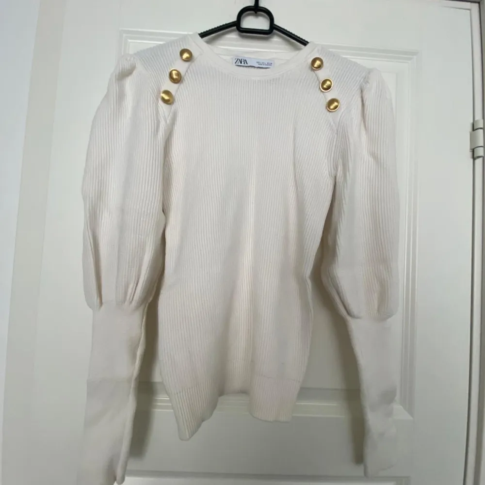 Jättefin vit tröja från Zara med guldiga knappar.  Tröjan är i fint skick, använd Max 2-3 gånger.  Tröjan är I storlek L men liten i storleken så skulle säga den är som M.. Tröjor & Koftor.