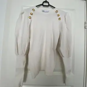 Jättefin vit tröja från Zara med guldiga knappar.  Tröjan är i fint skick, använd Max 2-3 gånger.  Tröjan är I storlek L men liten i storleken så skulle säga den är som M.