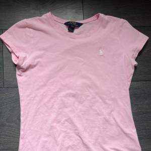 Rosa Polo Ralph Lauren t-shirt som är i bra skick men tyvärr för liten. På lappen står det L men de är i ”barnstorlekar” den sitter som xs ❤️ Pris kan diskuteras!!