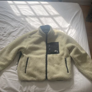 Stussy 8 ball reversible sherpa fleece Beige - Lätt använd, har lite smuts på insidan av jackan men inget man märker av, säljer den pågrund av att jag inte använder den lika mycket som jag gjorde förut 