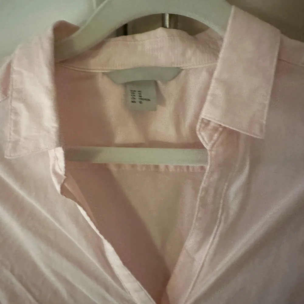 Elegant skjorta som sitter smickrande på kroppen- ursäkta att den lite skrynklig.  Den är ljus rosa i färgen Storlek M/L.  Nytt och oanvänd. Skjortor.