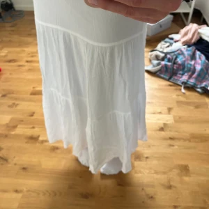 Vit långkjol - Fin vit långkjol, perfekt till sommaren✨ Bra längd (jag är 166), slutar precis ovanför fötterna. Innertyg vilket gör att den inte är genomskinlig. Använd fåtal gånger, så mycket bra skick💗 Köpt från Zalando, nypris ca 350kr🥰