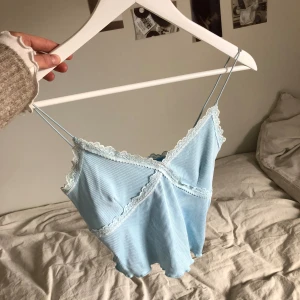 Ljusblått linne med spetsdetalj🩵 - Fint linne i ribbat material med spetsdetalj. Spagettiaxelband. Nyskick.