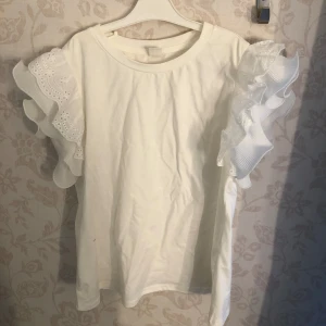T-shirt  - T-shirt med gulliga volanger på ärmarna🤍 använt fåtal gånger och är därför i bra skick 