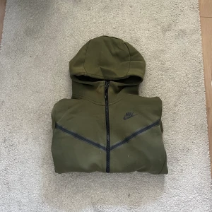 Nike tech - Den har fläckar på sig på framsidan och den är också lite nopprig, därav priset. Har däremot inte testat att ta bort fläckarna. Mansmodell XS men sitter som M på mig som har S/M i vanliga fall